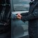 A private driver opens the door of a minibus